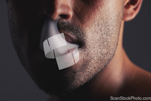 Image of Smoke, black man and face marijuana with cancer awareness and with bad habit with black studio background. Addiction, mouth with smoking cloud and male with drug puff with weed, vape and cigarette.