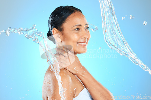 Image of Mature woman, wet or water splash on blue background in studio skincare wellness, hygiene maintenance or body cleaning. Smile, happy or beauty model with pouring liquid healthcare or hydration motion