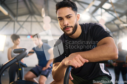 Image of Gym, portrait and man exercise on spinning bike for health, training and fitness goal at a sports center. Personal trainer, coach and mexican man with a vision for wellness, heart health and workout