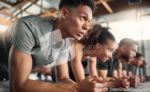 Image of Gym, fitness and plank floor workout, challenge and power exercise by young people, focus and mindset. Training, planking and group on the ground for wellness, health and muscle, energy and strength