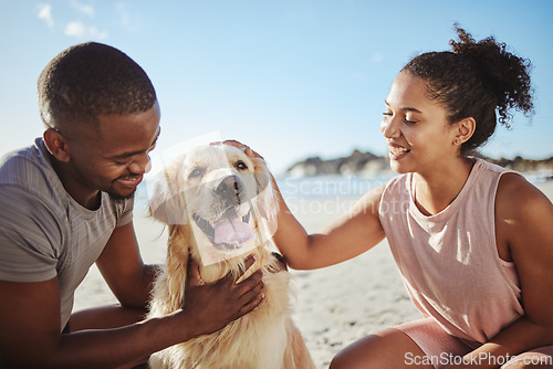 Image of Relax, couple and dog at a beach, happy and smile while bonding, sitting and touching their puppy against blue sky background. Love, black family and pet labrador enjoy a morning outing at the ocean