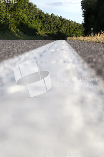 Image of close-up of an asphalt road with white road markings