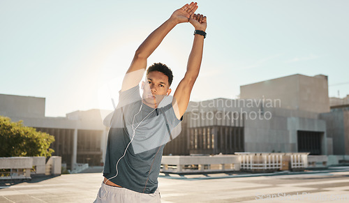 Image of Fitness, earphones and man stretching in city while streaming music, radio or podcast. Health, wellness or male from India warm up while listening to audio, song or sound track in town in the morning