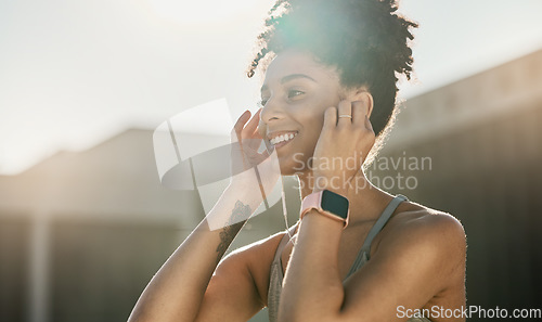 Image of Fitness, music and black woman doing exercise in city with earphones, smile and ready for training. Workout, running and young female athlete doing sports in town listening to track, audio and radio