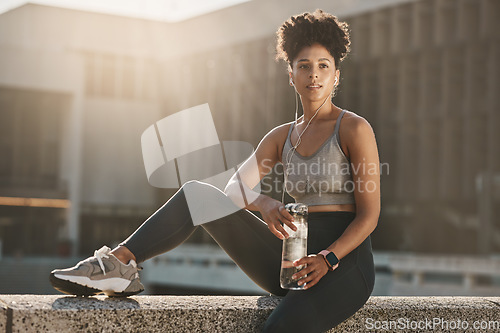 Image of Fitness, earphones and black woman, water bottle break and training workout, exercise and motivation in urban city. Thinking young athlete, sports hydration and nutrition for body, wellness and goals