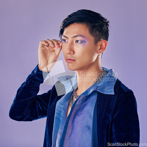 Image of Punk, rock or gay man with eyeshadow, makeup and cosmetics, vintage or retro fashion clothes on a purple background for pop art style. Asian lgbtq identity model in studio for creative color mockup