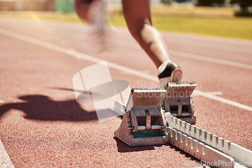 Image of Sports, fitness and running with a start block on a track for a competitive race in a stadium or arena. Health, workout and exercise shoes with a runner at the beginning of a sport competition