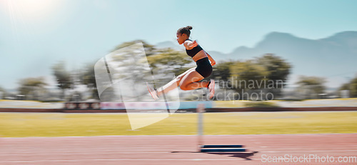 Image of Athlete, sports and woman jump hurdle for track and field event for obstacle race or course for running, exercise and training for marathon. Female outdoor for sport, workout and energy at a stadium