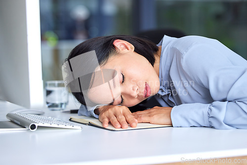 Image of Burnout, tired and business woman sleeping on the desk in her modern office while planning a strategy. Fatigue, overworked and professional employee taking nap at workplace while working on a project