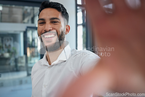 Image of Selfie, happy and success with a business man taking a picture while standing alone in the office at work. Portrait, confidence and smile with a male employee posing for a photograph while working