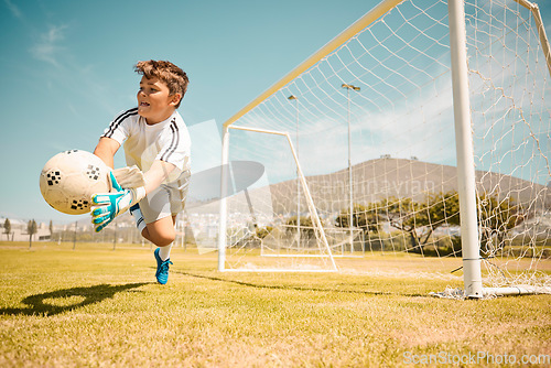 Image of Football, boy goalkeeper and jump, saving ball from goals at outdoor sports field. Soccer, kid and competition game with fitness, goal keeper and soccer ball on grass, success and action to save goal