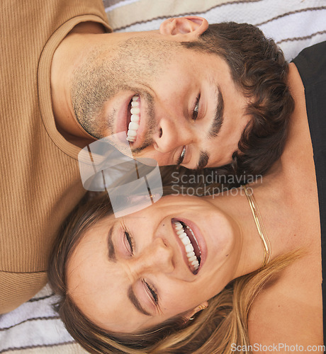 Image of Above, love and couple with a smile on a blanket at a park during a date, holiday or picnic. Comedy, happy and face of a funny man and woman laughing on a vacation together on the ground in nature