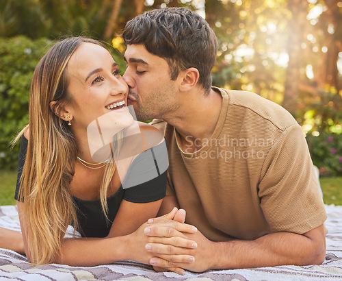 Image of Couple, holding hands with kiss and love in the park, picnic for bonding and happy in nature together. Support, trust and care with romantic date and outdoor fun, commitment and happiness.