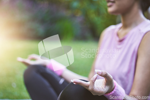 Image of Hands, meditation and fitness with a black woman athlete sitting on a field of grass for zen or wellness. Yoga, nature and meditate with a female yogi training in a park for balance or health