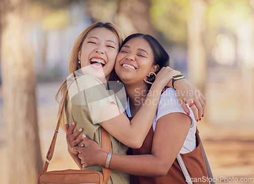 Image of Women, friends and happy hug in outdoor sunshine with embrace, love and smile in summer for vacation. Diversity, asian woman and black woman with happiness in nature, park and together in Jakarta