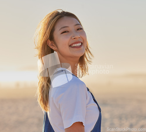 Image of Happy, asian woman and portrait smile on the beach for fun, travel or vacation trip in the outdoors. Japanese female smiling for joyful holiday walk or traveling in happiness by the sandy ocean coast