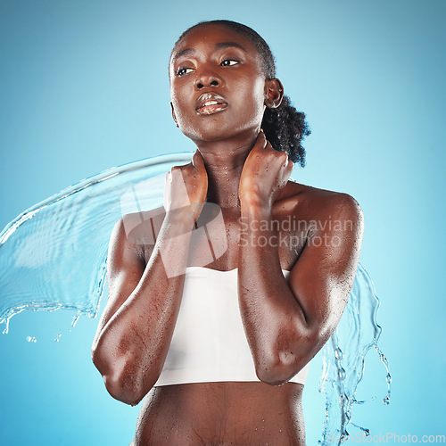 Image of Beauty, skincare and water splash for black woman in studio for cleaning, shower and wellness with cosmetic and dermatology product for skin. Jamaica model on blue background for self care and health