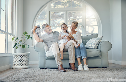 Image of Happy, relax and grandparents with a child on sofa in the living room at family home. Happiness, grandmother, grandfather and girl kid sitting on couch together while playing, bonding and relaxing.