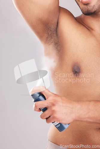 Image of Man, armpit or underarm deodorant spray on gray studio background for bathroom hygiene, healthcare wellness or fragrance smell. Zoom, hands or model with body odor product in morning grooming routine