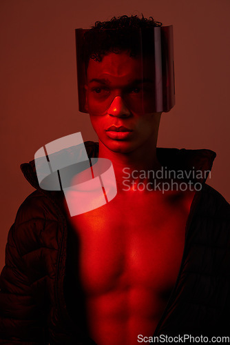 Image of Cool, cyberpunk and man with glasses for futuristic style, fashion and creative digital design in a neon room with studio background. Aesthetic art, dark and model with red lighting for creativity