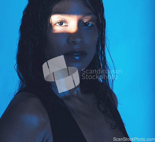 Image of Beauty, portrait and shadow girl with spotlight for skin health, skincare or cosmetic advertising. Sweaty, edgy and natural cosmetics black woman with blue studio background for marketing.