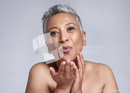 Image of Beauty, mature woman blowing a kiss and cosmetics in studio background portrait. Skincare, happy senior lady kissing air and sending love in celebration of life, wellness and happiness in retirement.