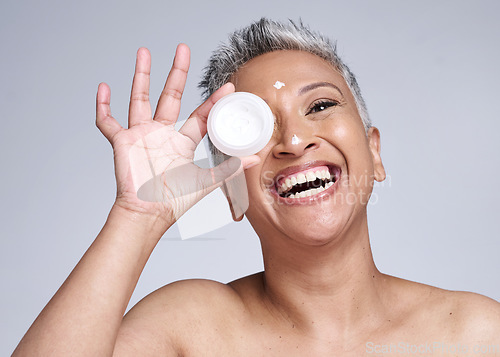 Image of Mature woman, laughing and skincare cream in healthcare grooming, collagen glow wellness or facial dermatology routine. Smile, happy or beauty model with sunscreen product on Indian studio background