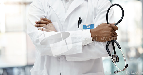 Image of Healthcare, hospital and hands of doctor with stethoscope standing in clinic with arms crossed. Leadership, support and african american health care worker with medical equipment for innovation