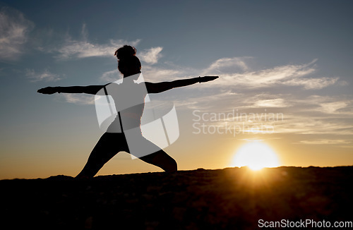 Image of Silhouette, yoga and sunset with woman on rock for training, fitness and zen wellness. Spiritual, faith and health with pilates girl workout with warrior pose in nature for relax, peace and balance