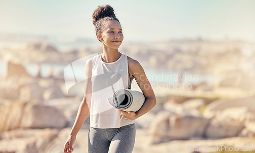 Image of Beach, yoga mat and black woman with smile outdoor for meditation, wellness and peace to relax. African American female, lady and seaside walking, health or pilates for exercise, calm or seaside view