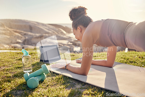 Image of Fitness, woman and tablet in yoga planking at the beach for exercise, training or workout in healthy wellness. Active female in plank pose for abdominal, abs or core strength with touchscreen outside