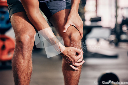 Image of Fitness, exercise and man with knee pain in gym holding leg after injury, accident and muscle pain. Healthcare, sports and male athlete with sore joint, hurt after exercising, workout and training