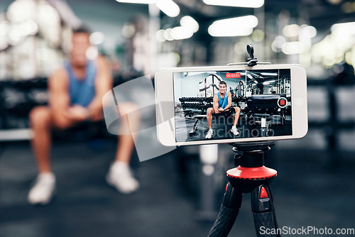 Image of Gym, social media and fitness influencer with phone live streaming workout for interactive multimedia broadcast. Vlog, man filming arm exercise and training coach video recording online blog tutorial