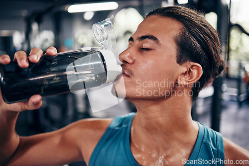 Image of Drinking water, fitness and gym man with challenge workout training for muscle, power and energy with motivation, goals and sweating. Tired sports, athlete person with water bottle in health exercise