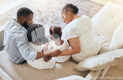 Image of Black family, care and love while bonding on living room couch with children, mother and father together with trust and support. Man, woman and young kids sitting on sofa to relax from top view