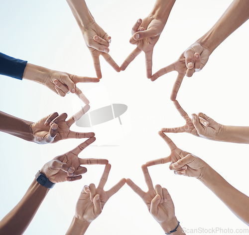 Image of Diversity, teamwork and hands with star shape for community, team building or support with a sky background. Collaboration, peace and bottom view of group of people with fingers in unity for bonding.