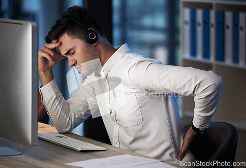 Image of Businessman, call center and back pain from burnout, headache or overworked late at night by the office desk. Man consultant suffering in pain, sore back or discomfort from long hours on the computer