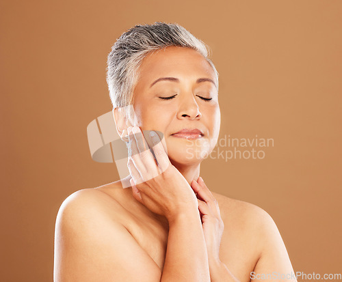 Image of Skincare, beauty and self care with a senior black woman on a brown studio background for makeup, cosmetics and dermatology mockup. Face glow, skin and botox for a mature model after a facial