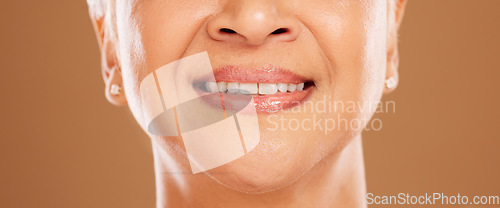 Image of Teeth, dental and senior woman in studio isolated on a brown background. Oral care, wellness or closeup smile of elderly female model with natural looking veneers for beauty and healthy tooth hygiene