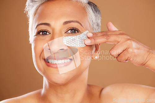 Image of Senior woman, skincare and beauty with a eye patch or collagen mask for a facial with cosmetics and dermatology product for clear and health skin. Face portrait of mature model happy about self care
