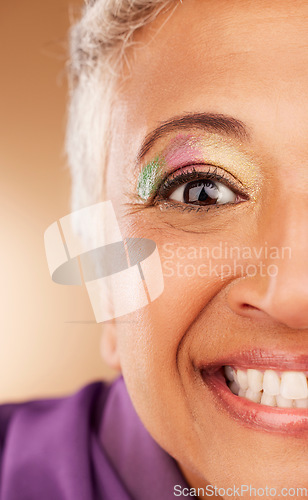 Image of Eye, makeup and woman being creative, colorful and smile for fun, happy and content with brown studio background. Cosmetics, elderly female or senior lady with glitter for happiness or natural beauty