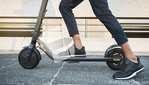 Image of Electric scooter, fashion and travel on a city street with black sneakers, energy and modern tech for eco friendly transportation. Future, hipster and energy of urban male legs on e scooter vehicle