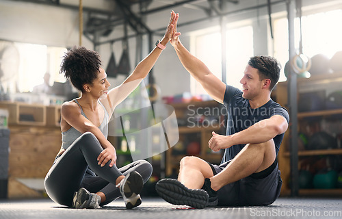 Image of High five, motivation and fitness with a man and woman celebrating as a winner pair together in a gym. Team, success and exercise with a male and female athlete training in partnership for health