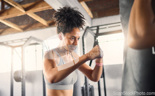 Image of Fitness, black woman and boxing for training, exercise or healthy workout for strength or endurance at the gym. African American female boxer in sports activity hitting punching bag for self defense