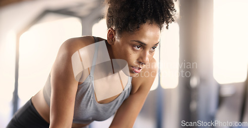 Image of Gym, training and tired black woman breathing after exercise, workout and sports fitness. Woman in a health and wellness club breathe and relax after intense athlete challenge with focus