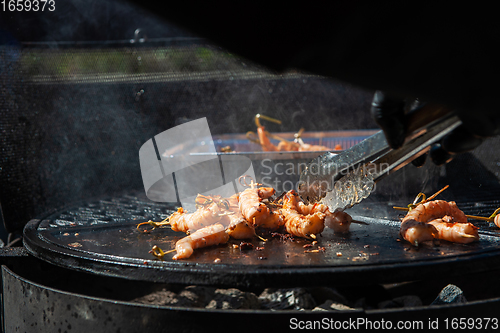 Image of A professional cook prepares shrimps