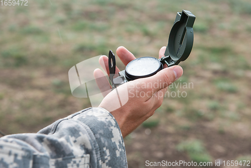 Image of Man with compass in hand outdoor