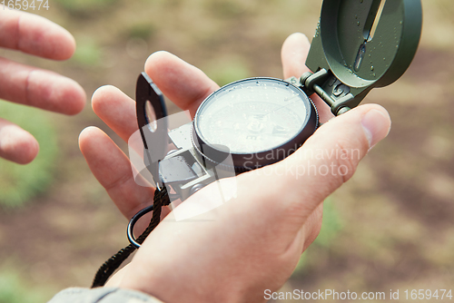 Image of Man with compass in hand outdoor