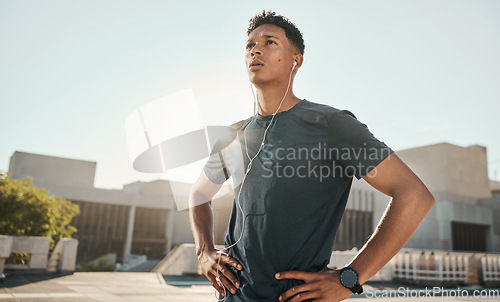 Image of Music headphones, sunshine and fitness athlete ready for cardio exercise, marathon training or performance workout. Runner determination, blue sky flare and black man listening to radio or podcast