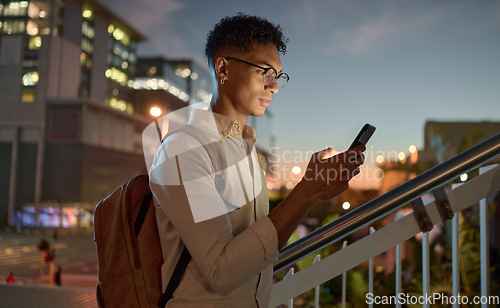 Image of Man, city night and phone text of a student on social media app, internet or web search. Black man with mobile technology in the dark online reading and texting with a 5g connection outdoor